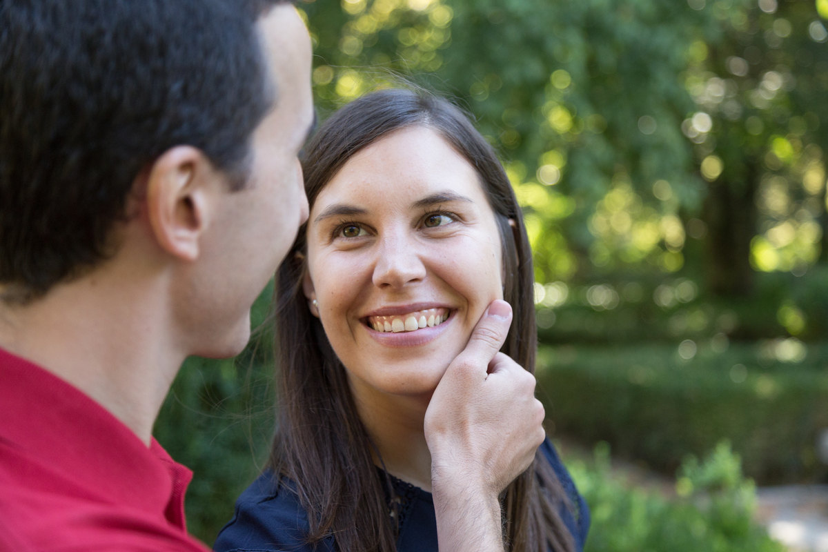 fotografia de namorada a sorrir para o seu noivo em sessão fotográfica engagement