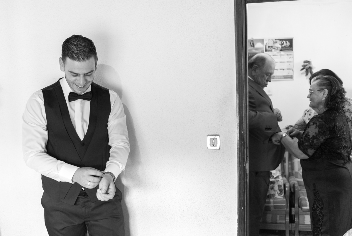 noivo a vestir-se com os pais na sala