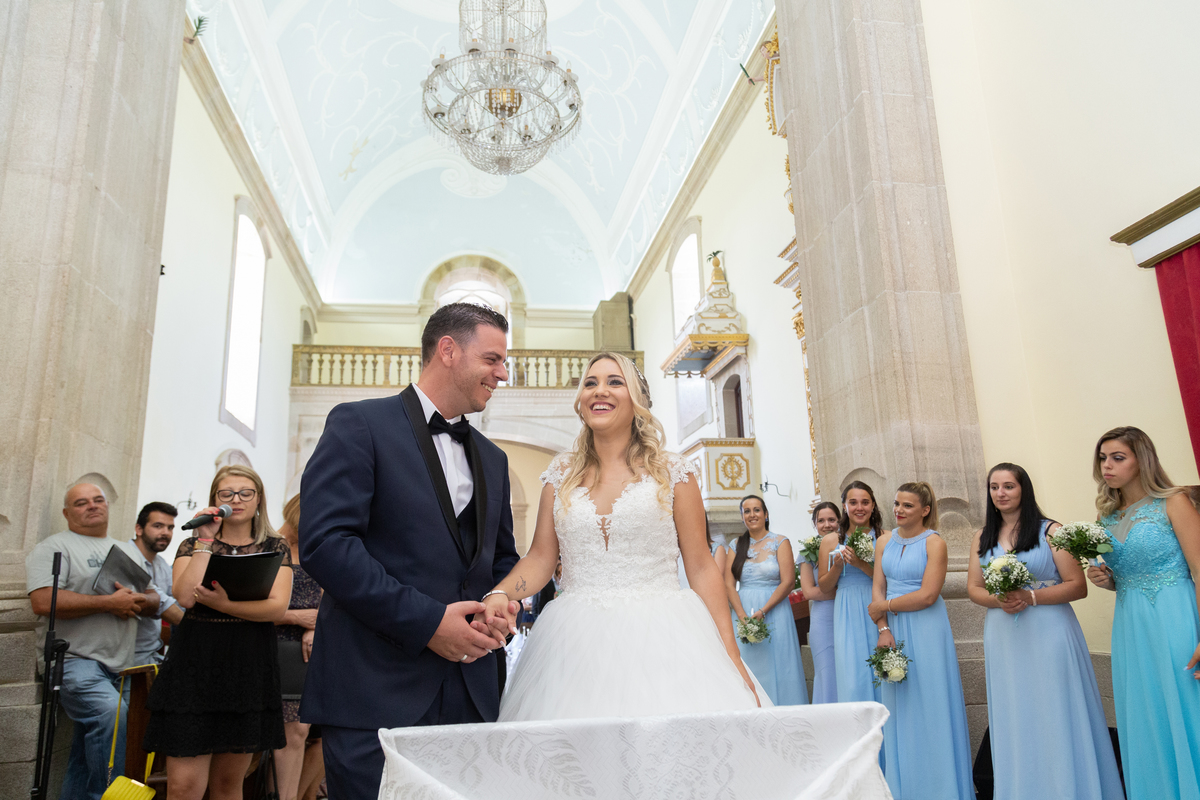 noivos na cerimonia na igreja com damas de honor