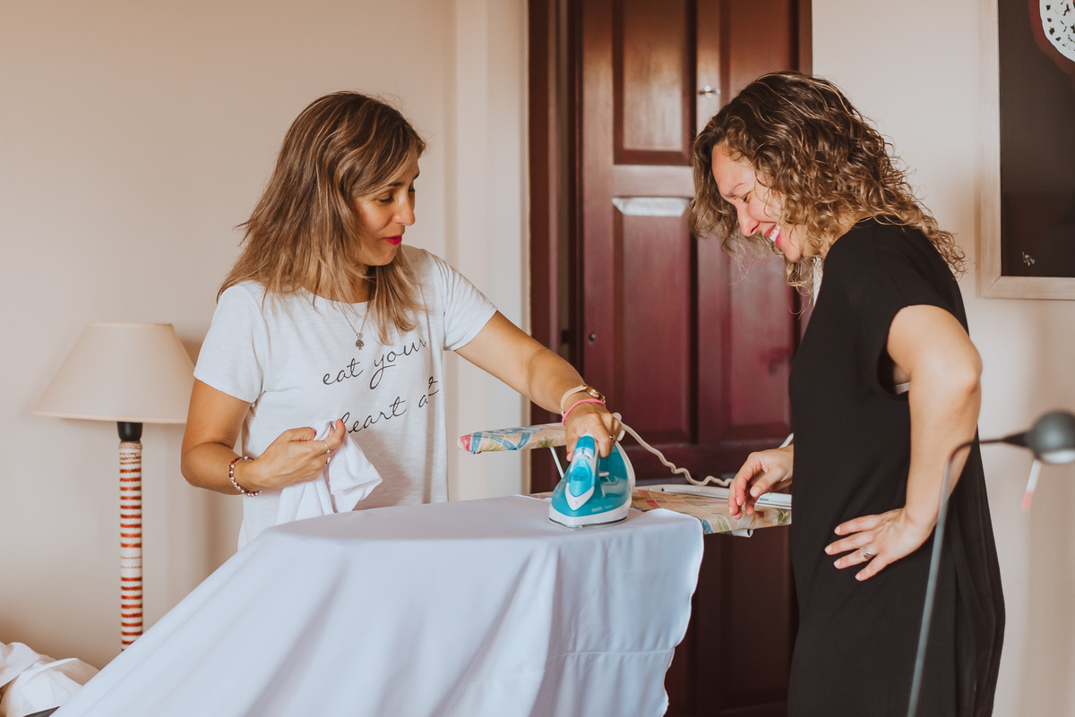 hermanas de la novia planchando el vestido momentos previos a la boda de dia