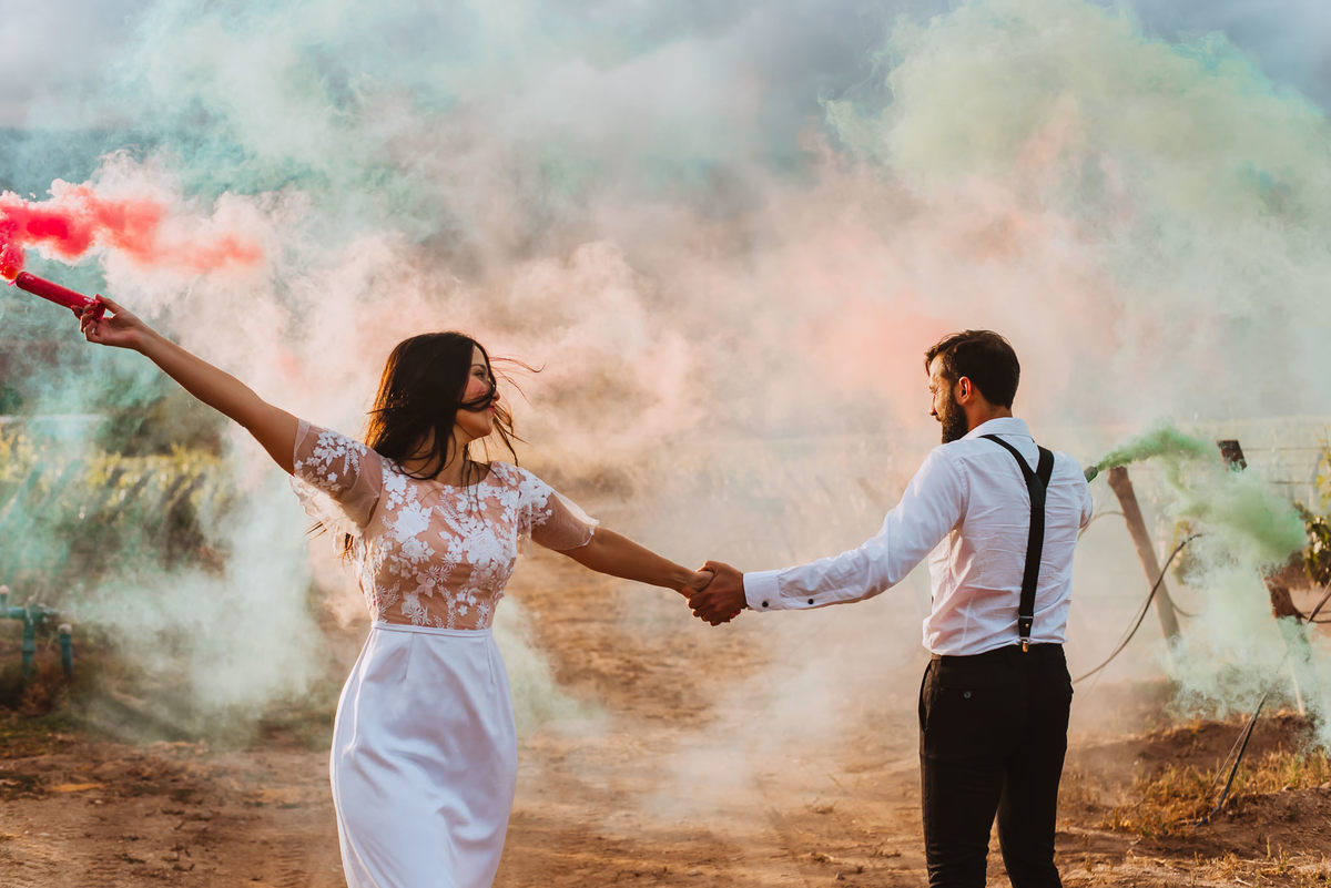 bailando juntos en el campo al aire libre con humos de colores novios felices fotografa de bodas en argentina salta peru 