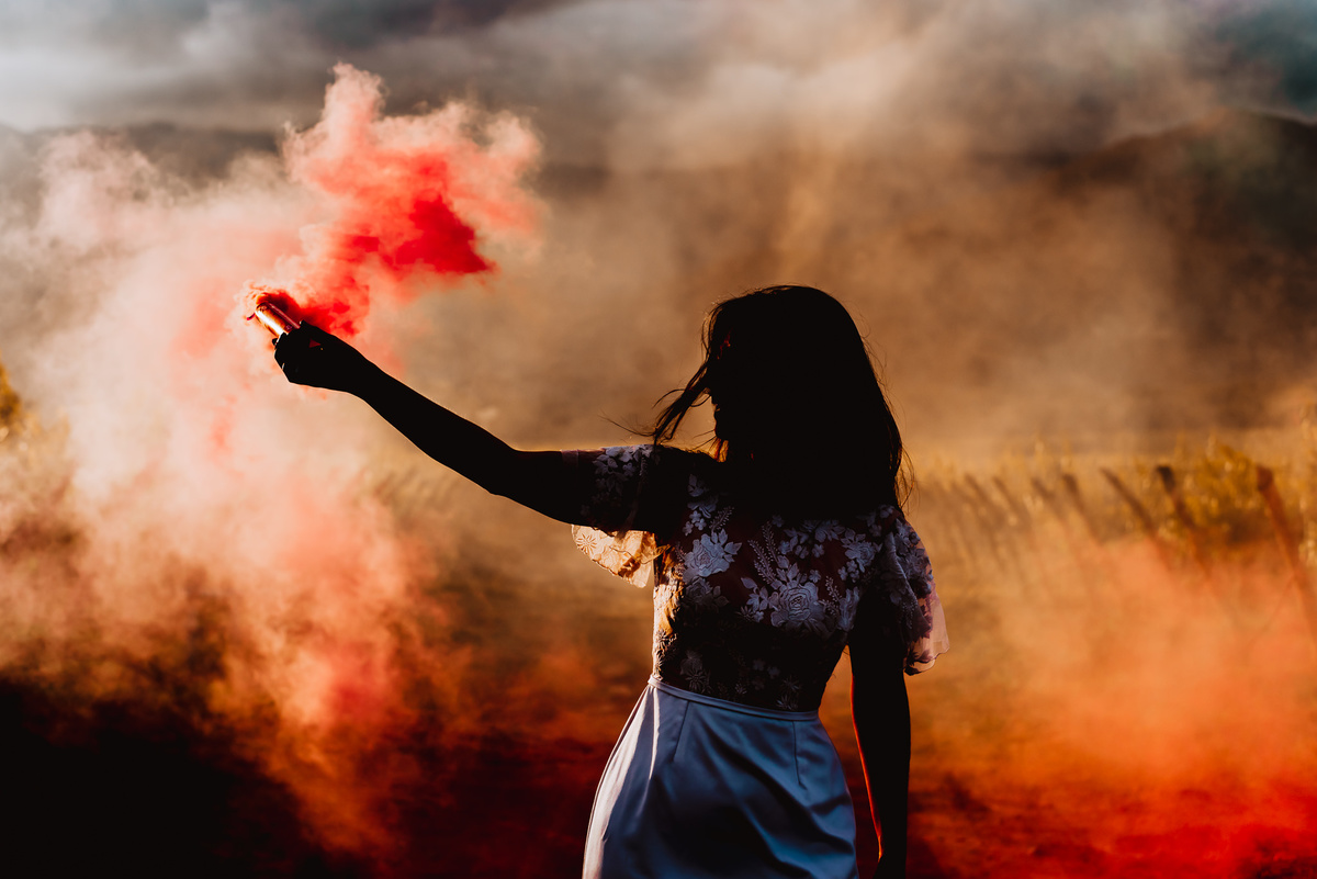 novia con humo de color en atardecer al aire libre en campo entre viñedos fotografa de bodas en argentina salta peru alejandra ramos fotografia