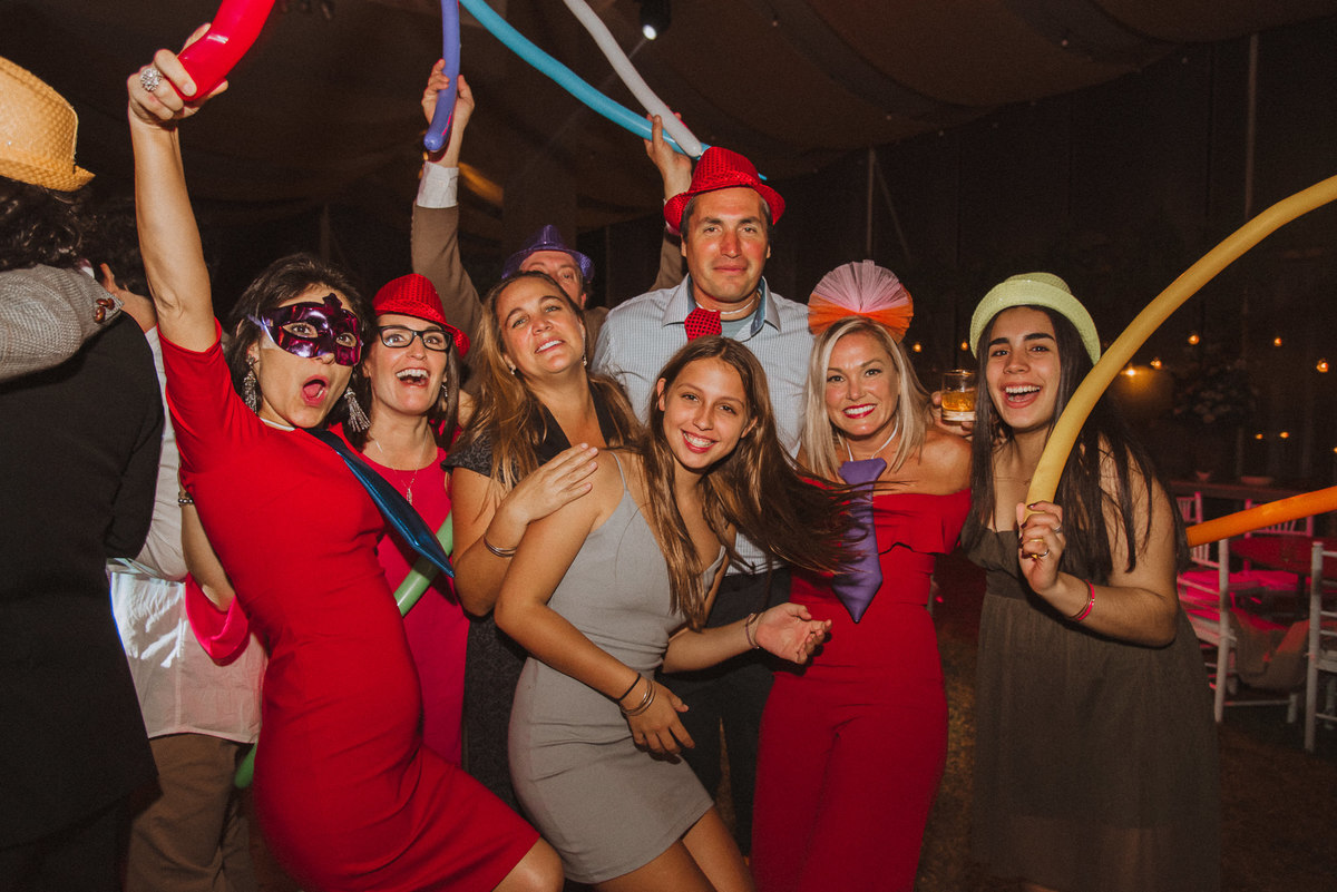 invitados celebrando felices hora loca cotillon mascaras globos foto grupal invitados