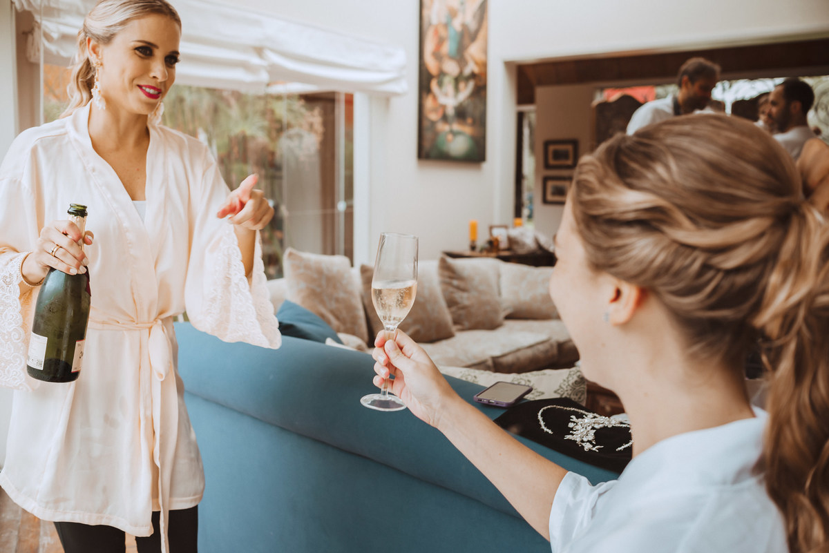 previa de la novia con familia hermana sirviendo el champagne brindis salud fotografa de bodas 