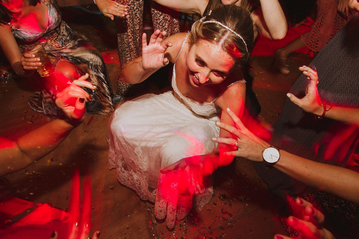novia bailando en el suelo con maigas luces manos alegre momento especial fotografa de bodas de confianza 