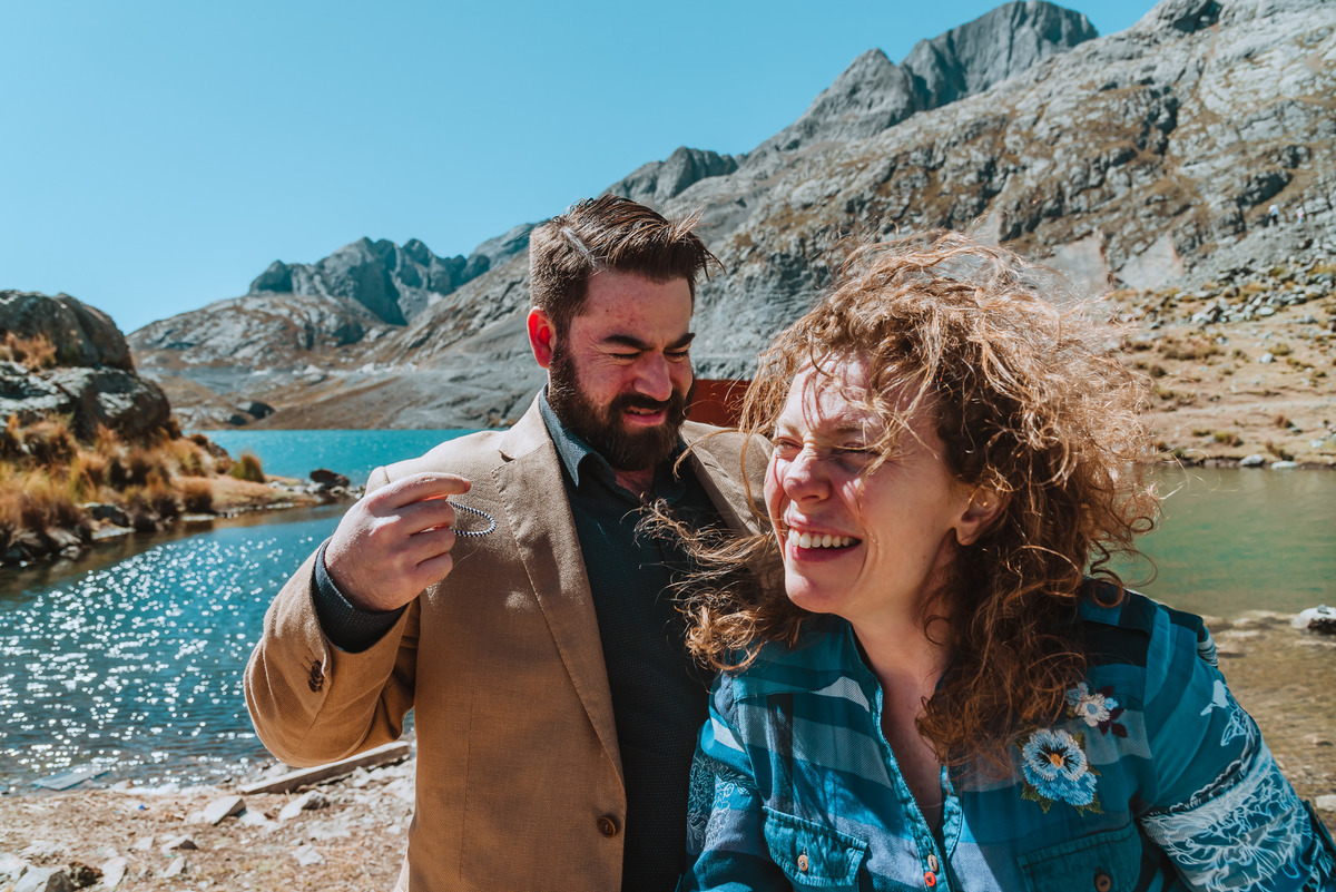 novios felices sesion al aire libre en peru canta naturaleza fotografa de bodas previa a la boda futuros esposos risas enamorados lago laguna 