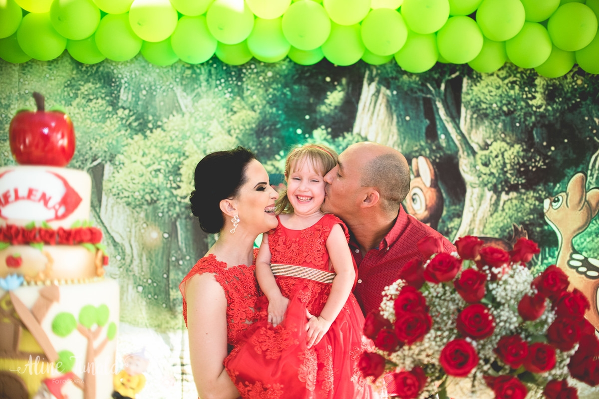 foto expontânea brincando com os pais na mesa do bolo no aniversário de 3 anos de branca de neve