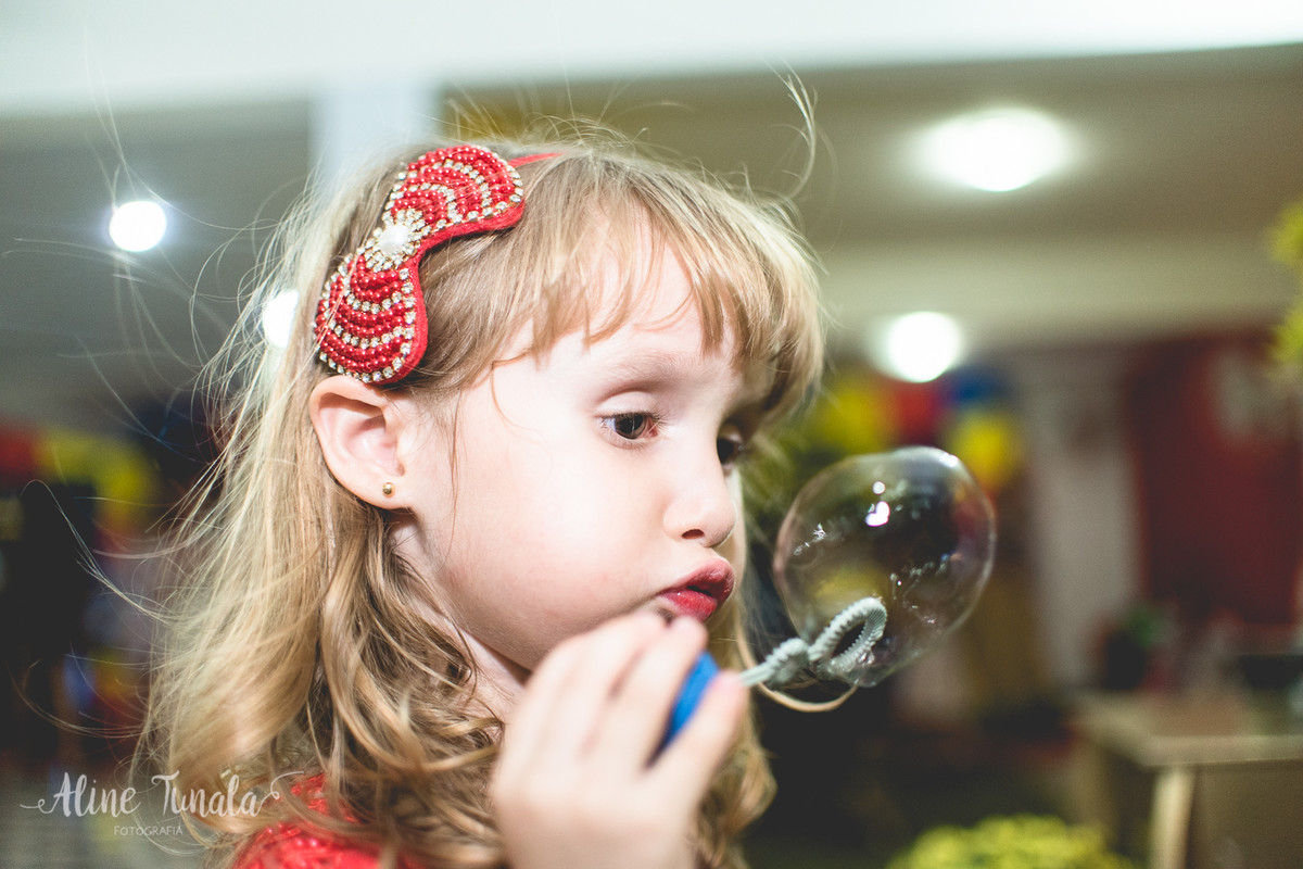 helena fazendo bolinha de sabão no seu aniversário
