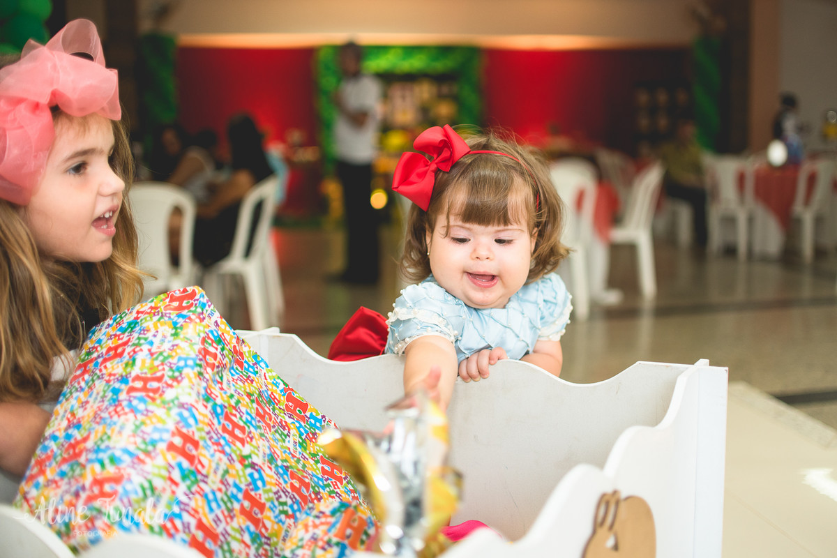 bebê mexendo nos seus presentes no seu aniversário de 1 ano