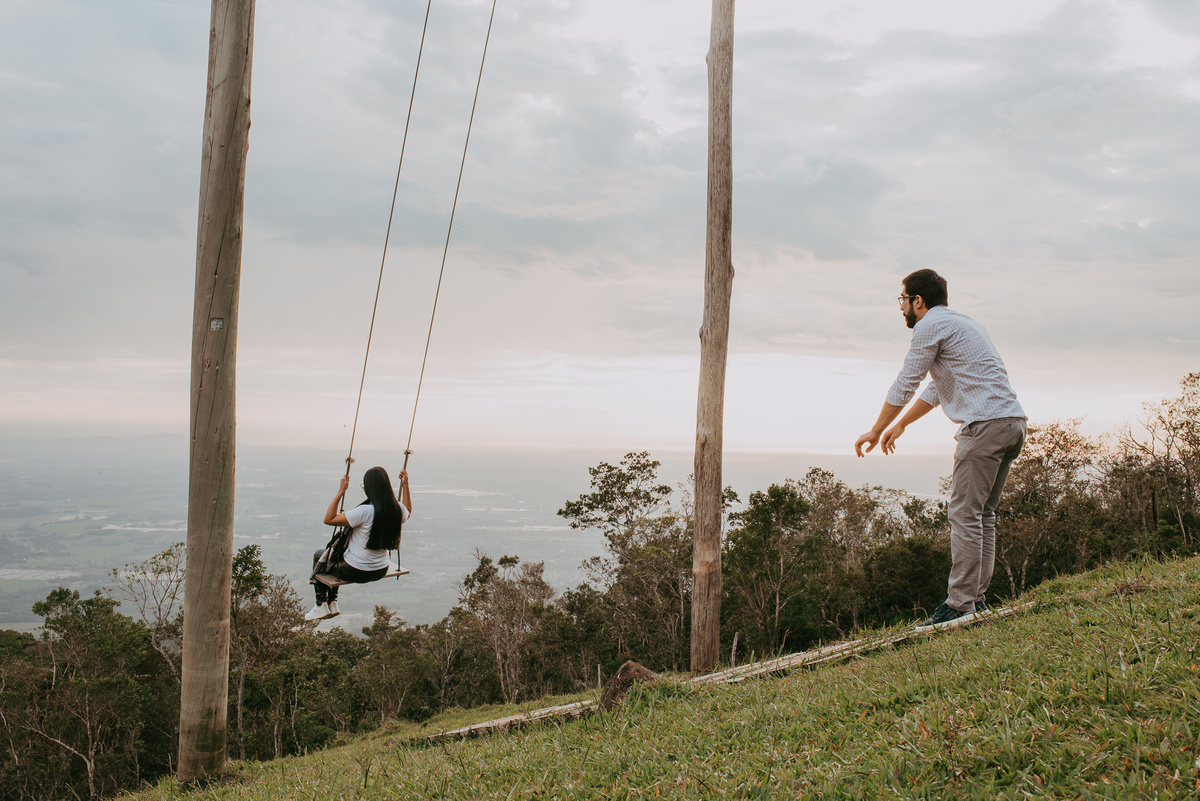 casal andando em um balanço infinito , em ensaio fotográfico casal , em praia grande SC, na encosta dos canyons após piquenique