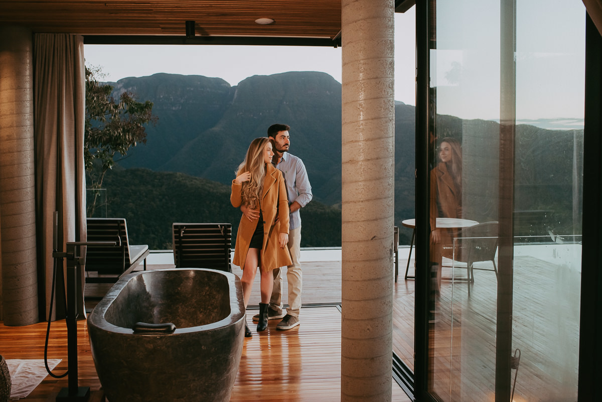 ensaio de um casal dentro da suite 2 na morada dos canyons em praia grande sc , admirando a beleza da amanhecer com balões de ar quente
