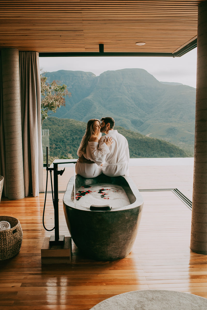 casal sentado na banheira da suíte 2 da morada dos canyons, ensaio durante a viagem , realziado por mai e anderson fotografia , fotografos , especializados em fotos de turismo em praia grande sc , cambara do sul RS