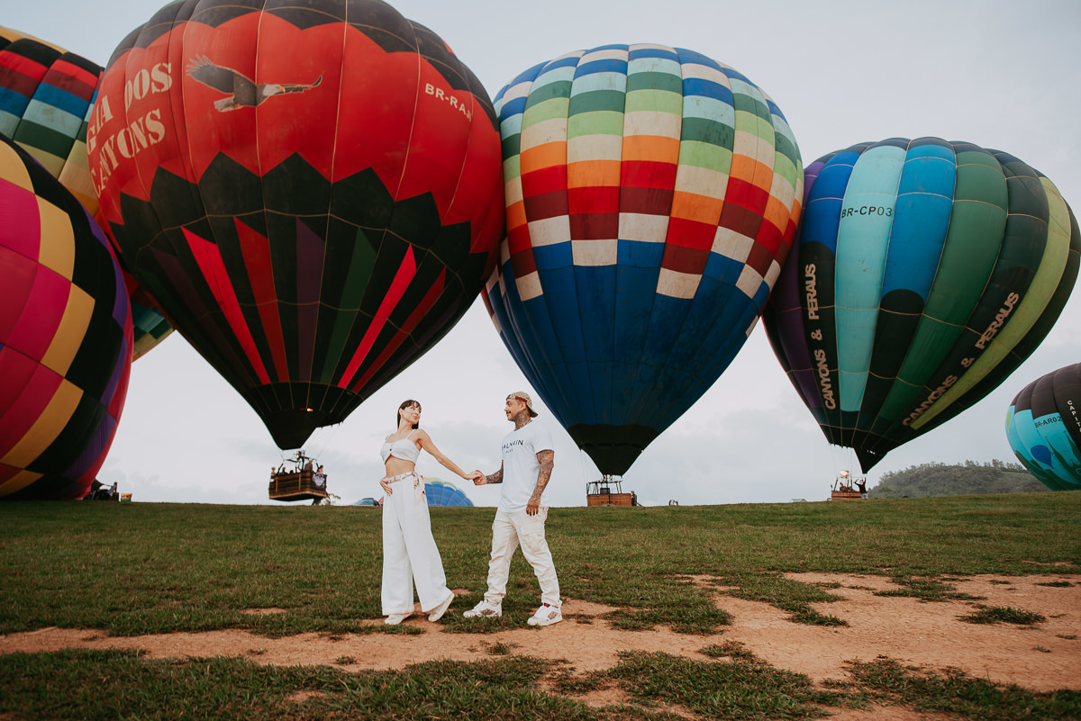 ensaio fotográfico de casal, andando no campo de decolagem , onde os balões decolam, ensaio chá revelação, balões coloridos decolando , Praia Grande SC 