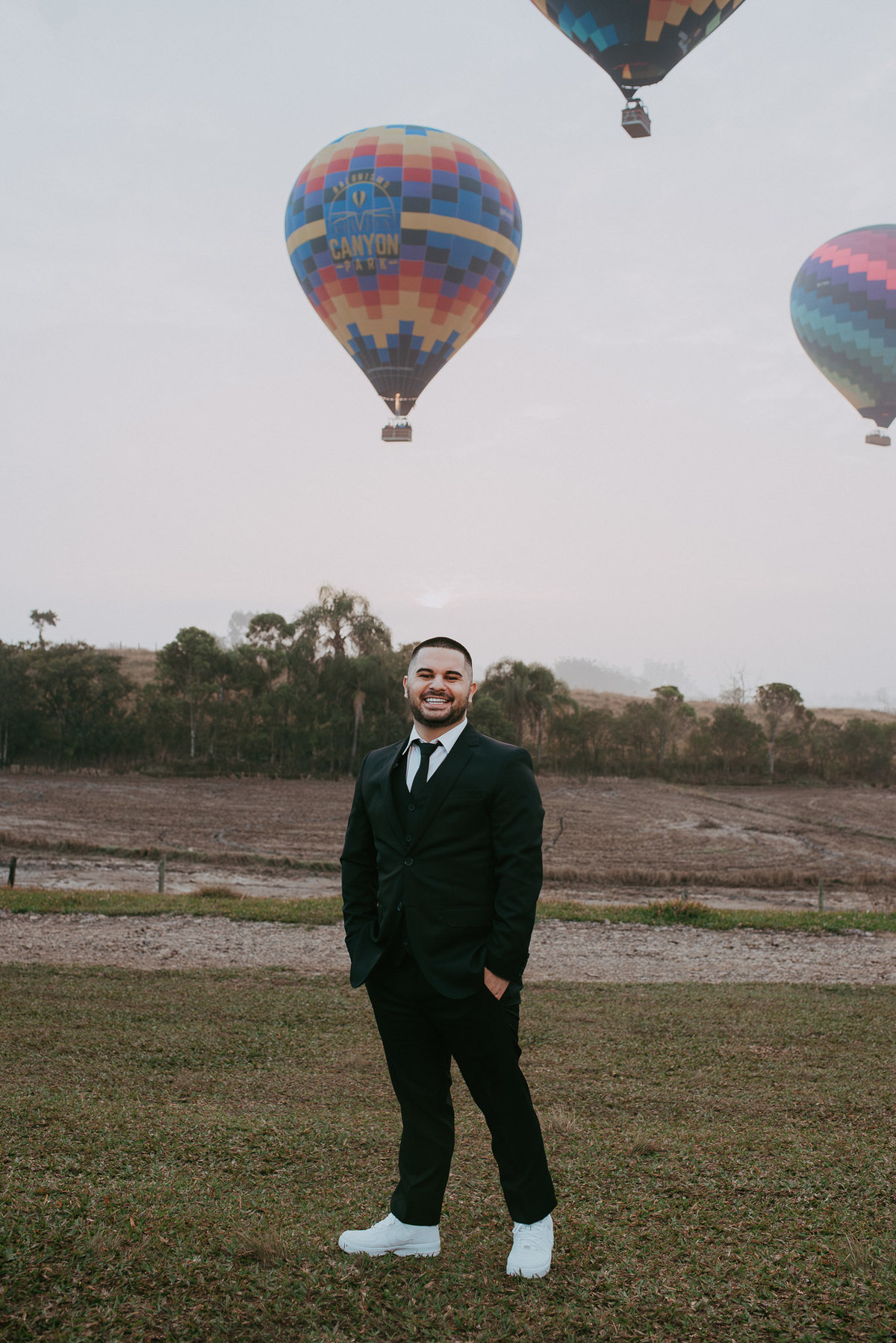 Casal registra amor em ensaio com balões e céu aberto.