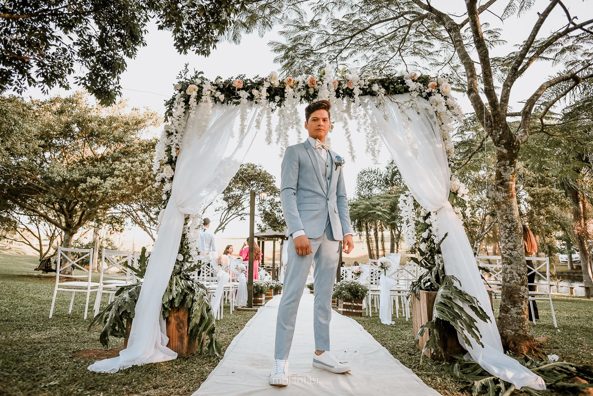 fotografia do noivo de terno azul bebe, pronto no inicio da cerimonia 