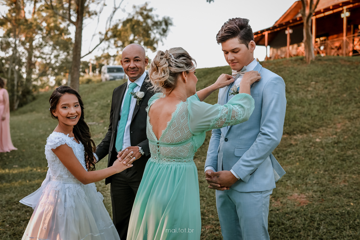 mão do noivo arrumando a gravata do noivo antes da entrada do casamento ao ar livre em içara 
