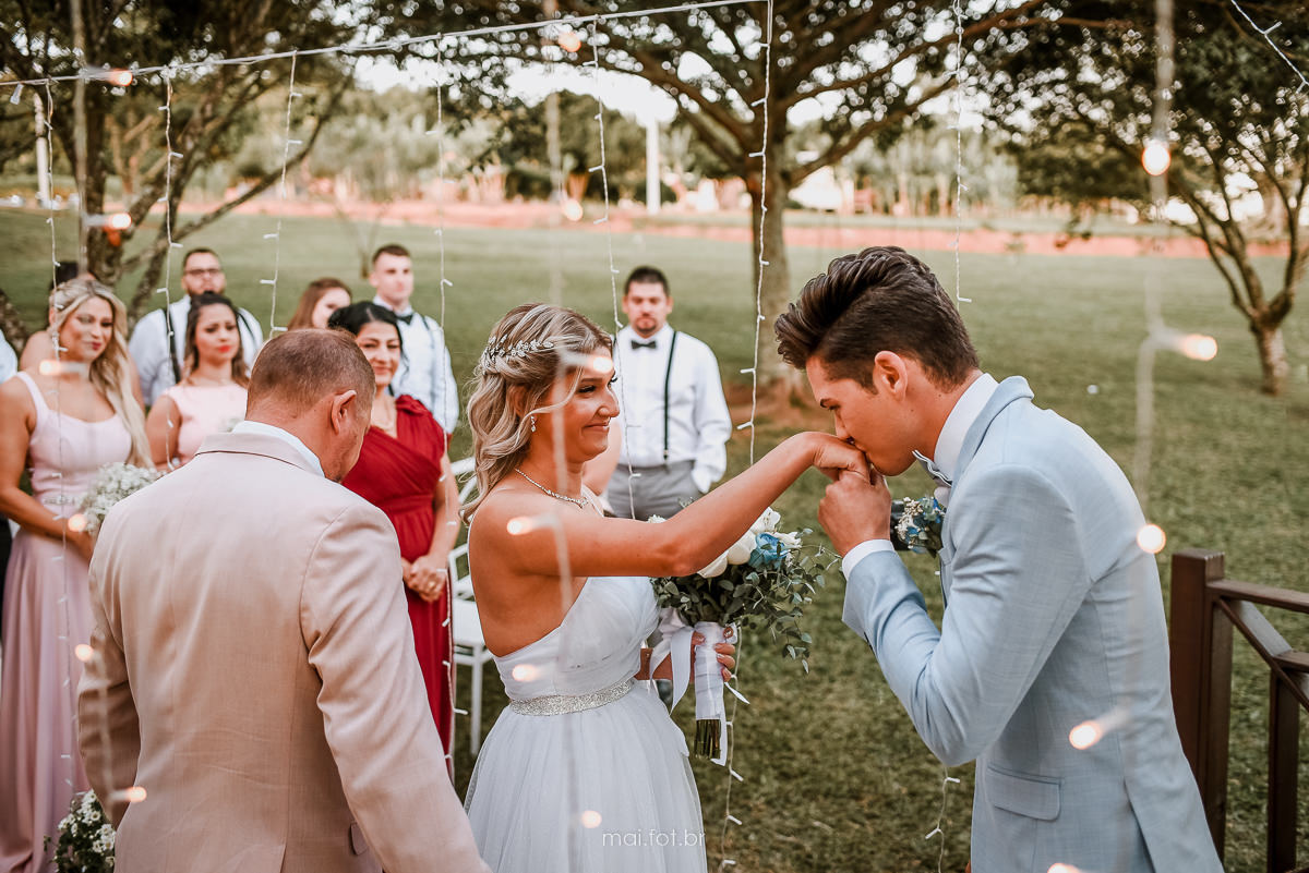 noivo beijando a mão da noiva, noivo recebeu a noiva para entrada do casamento ao ar livre em Santa Catarina  