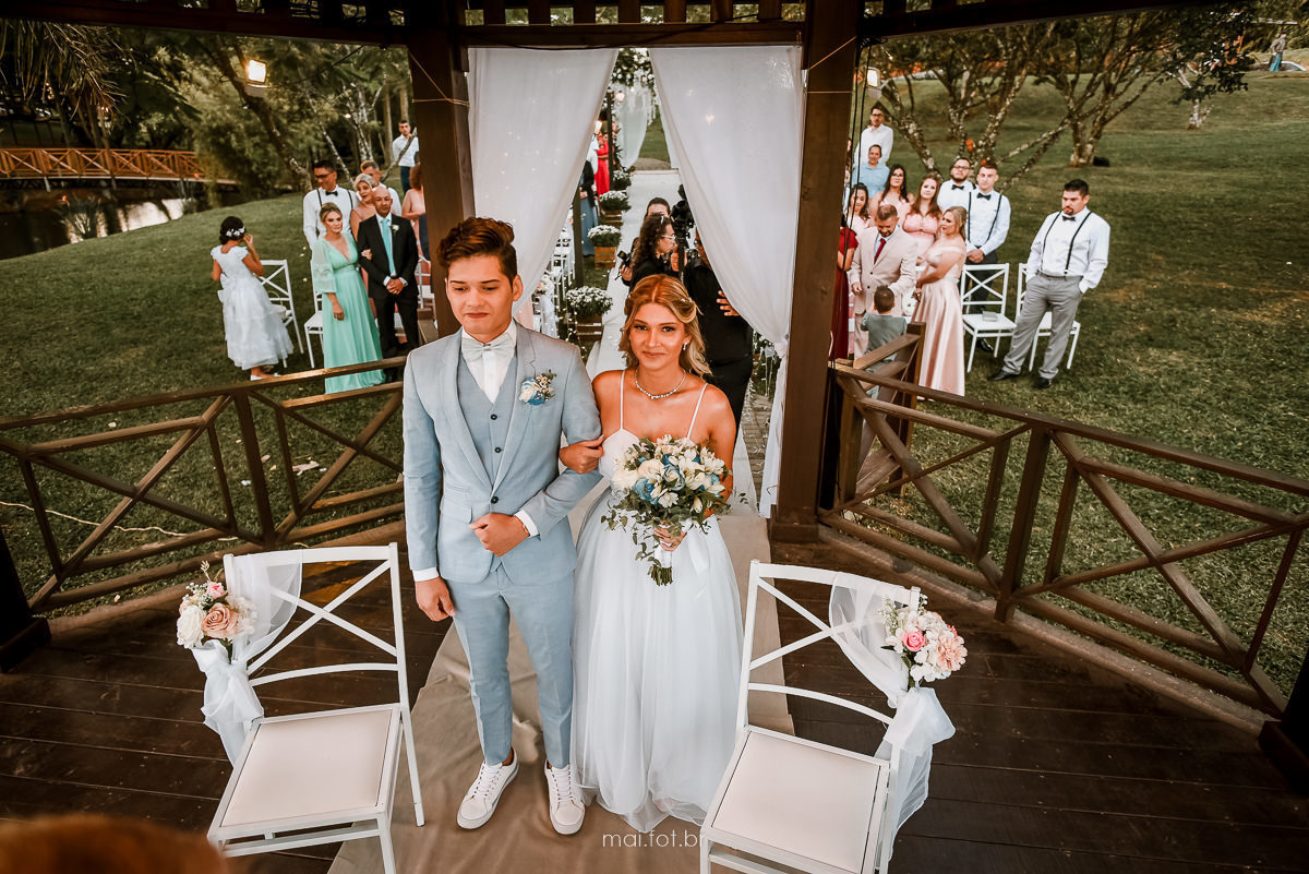 noivos no altar e convidados ao fundo assistindo a cerimonia de casamento da Carol e do júnior em içara 