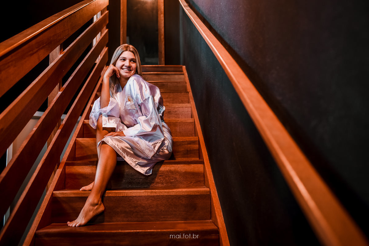 fotografia da noiva sentada na escada do salão de beleza, durante o making of 