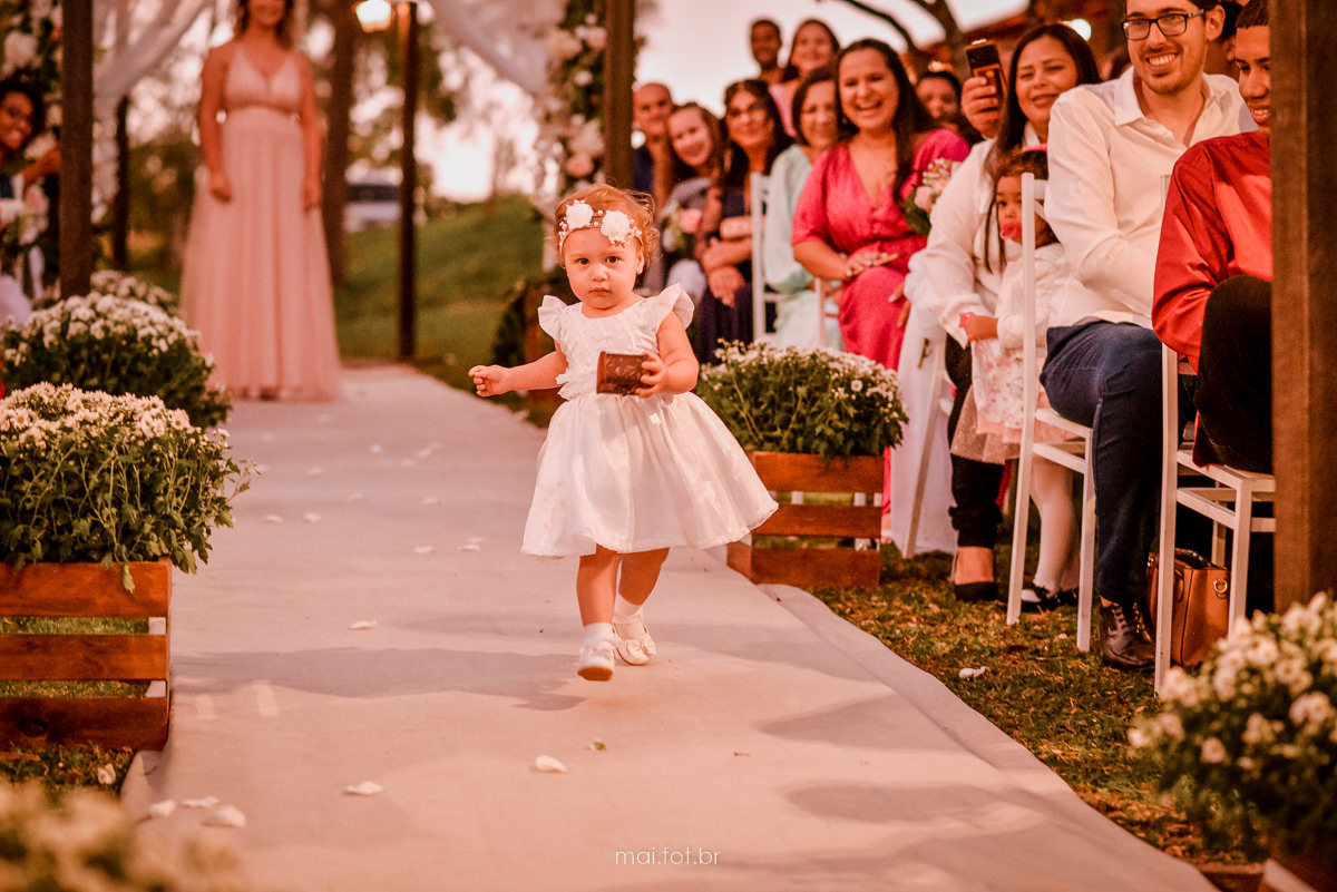 dama de honra entrando correndo com as alianças, para entregar aos noivos no altar, e convidados alegres 