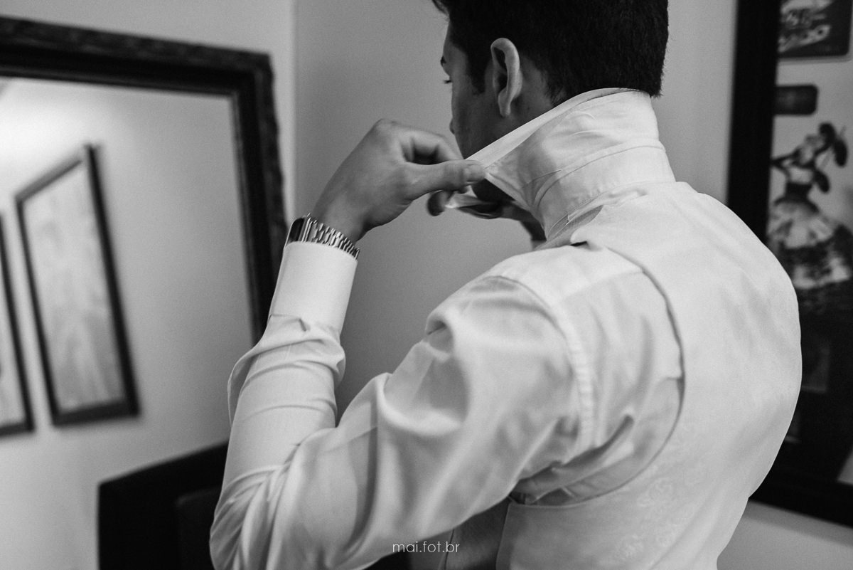 noivo colocando a gravata em frente ao espelho 