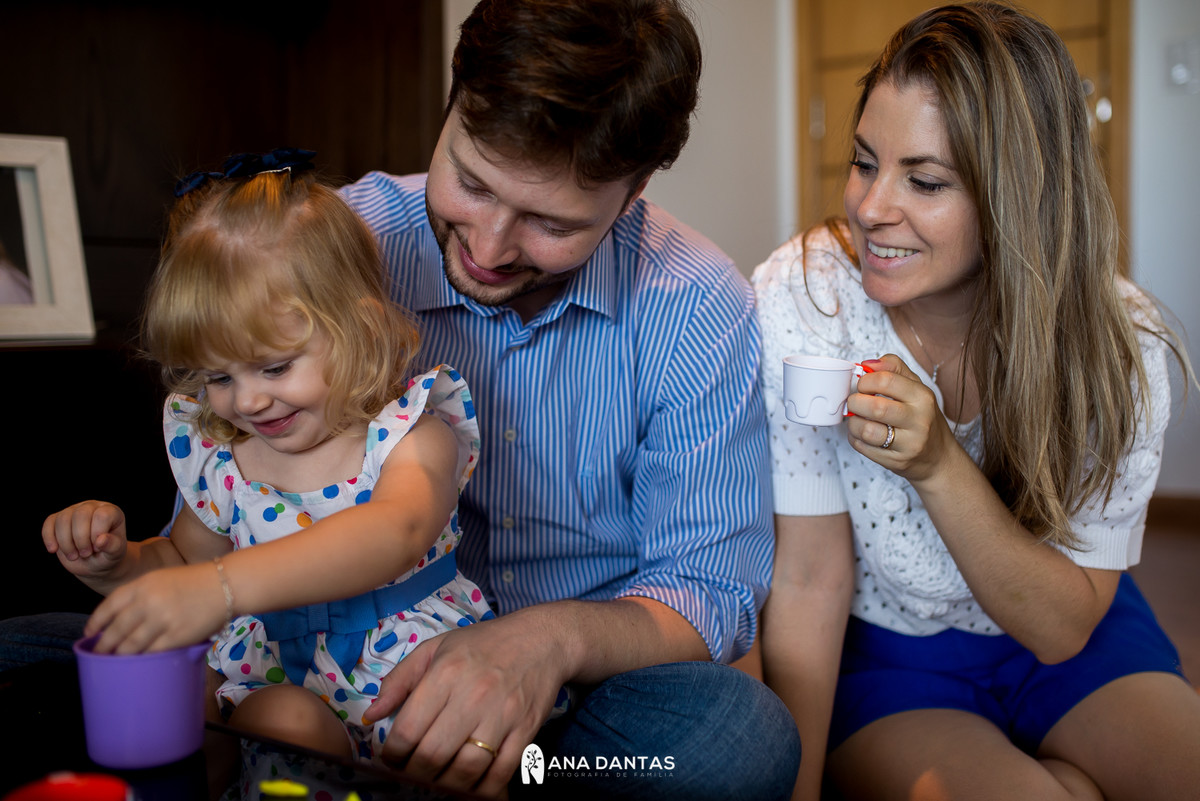 Mamae e papai brincando com a filha 