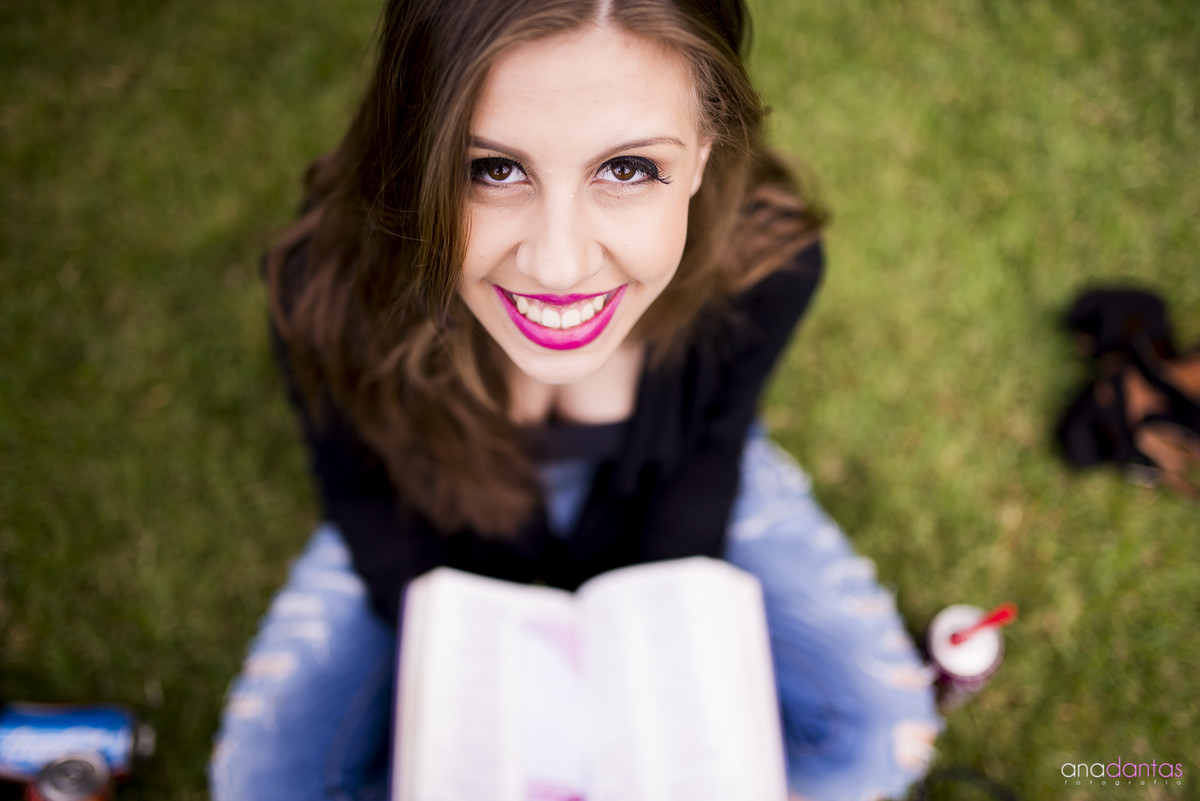 Moça lendo um livro em um campo