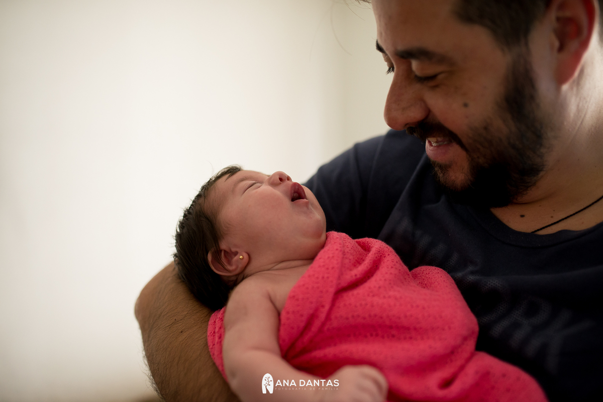 Neném chorando no colo do pai