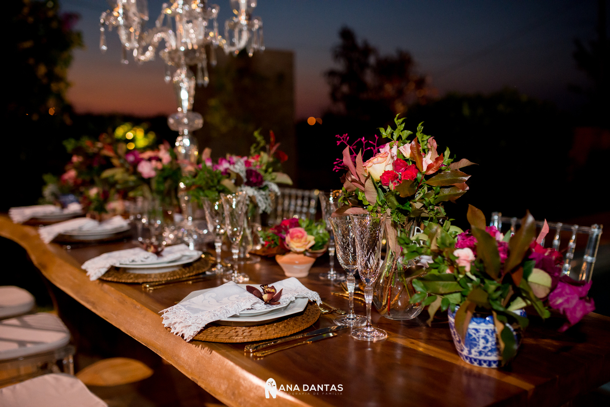 Decoração da mesa de madeira com flores e um por do sol atrás