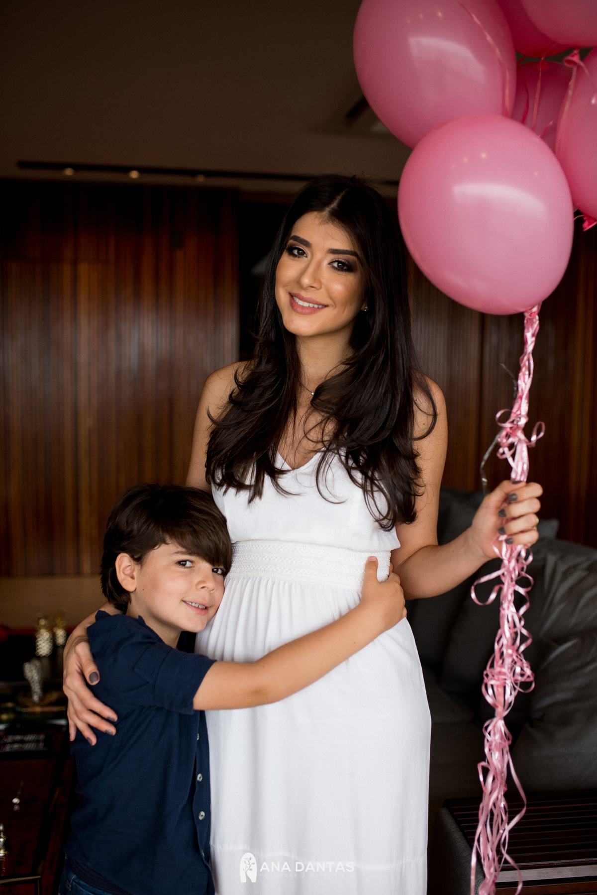 Menino abraçando a barriga com a irmã