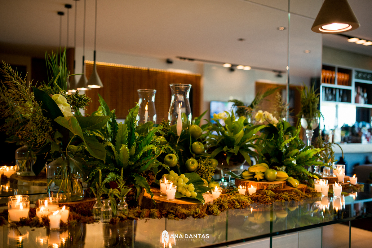 Mesa com muita decoração de folhas verdes
