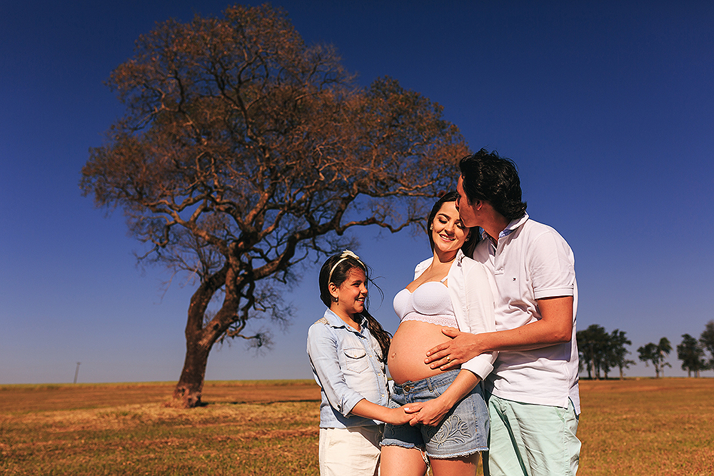 homem abracando a esposa e a filha olhando