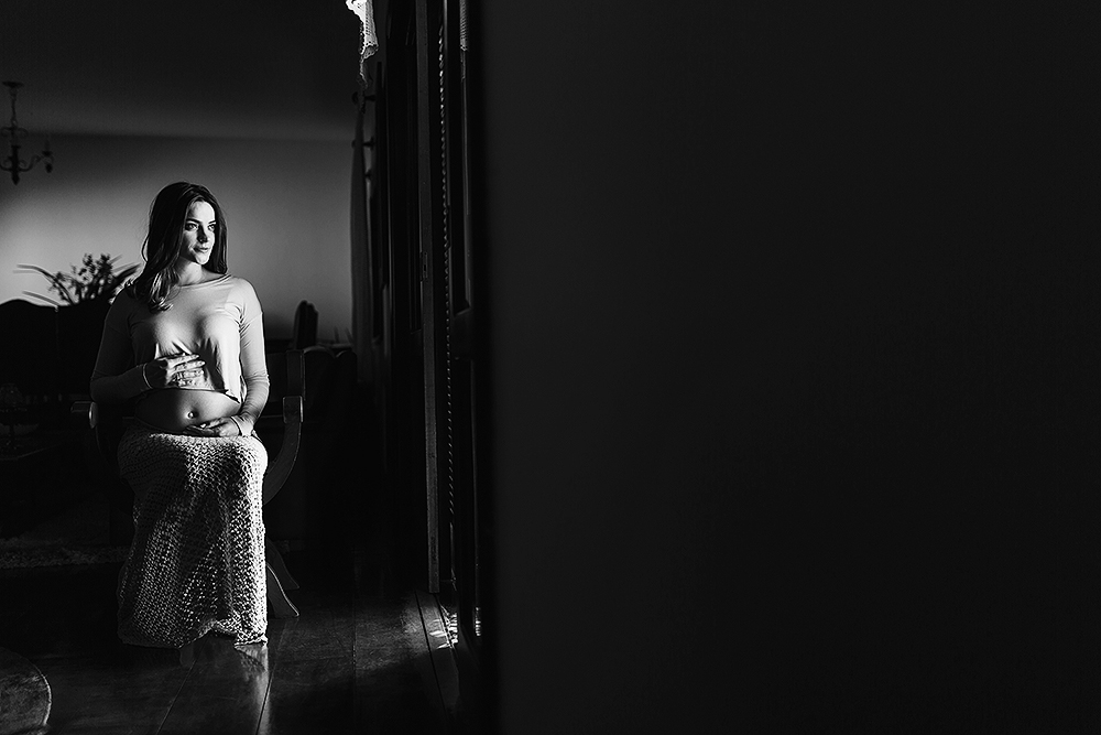 mulher sentada na cadeira olhando pela janela