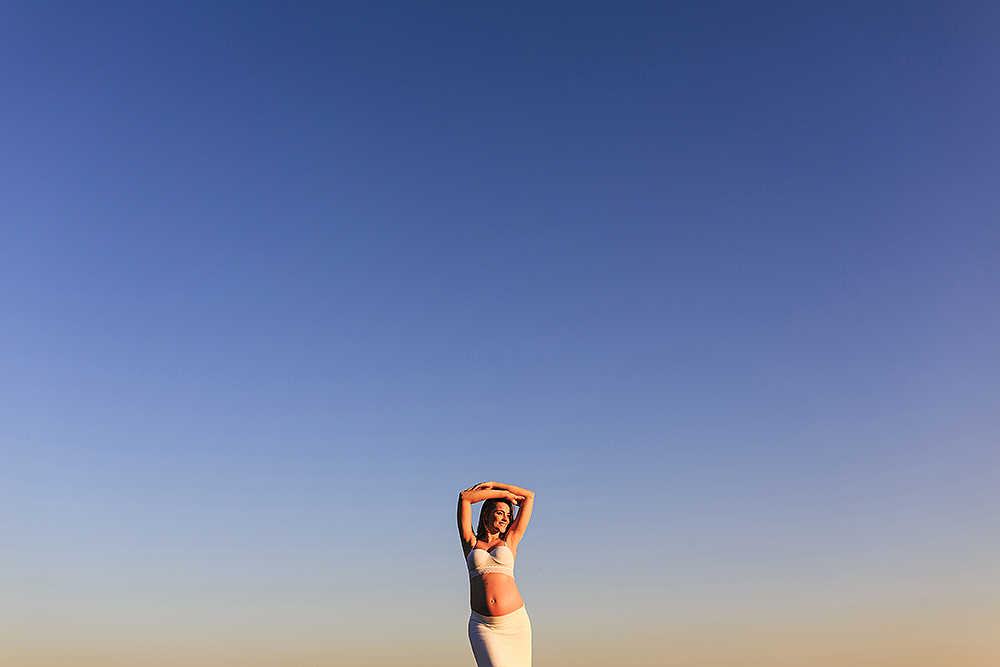 linda paisagem com a gestante com os braços em cima da cabeça