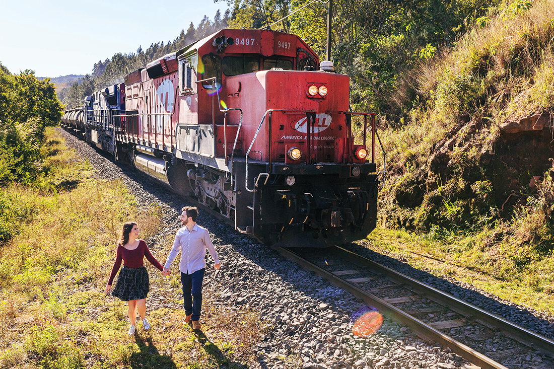 noivos correndo ao lado do trem vermelho
