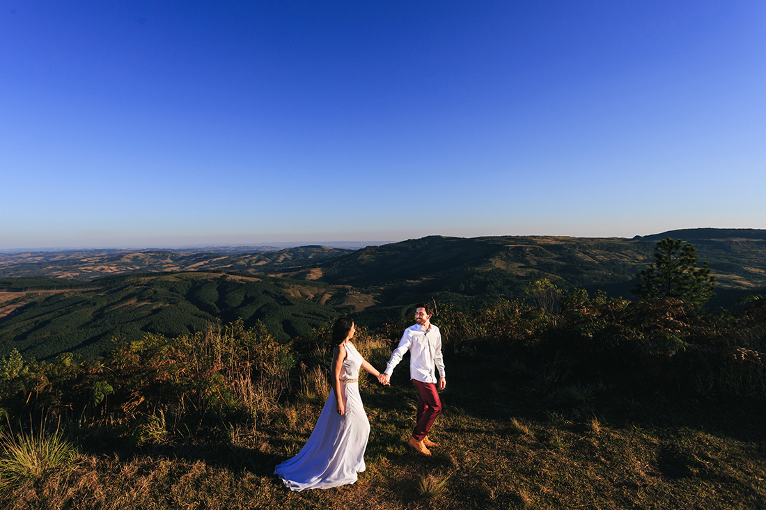 casal andando de maos dadas em cima da montanha