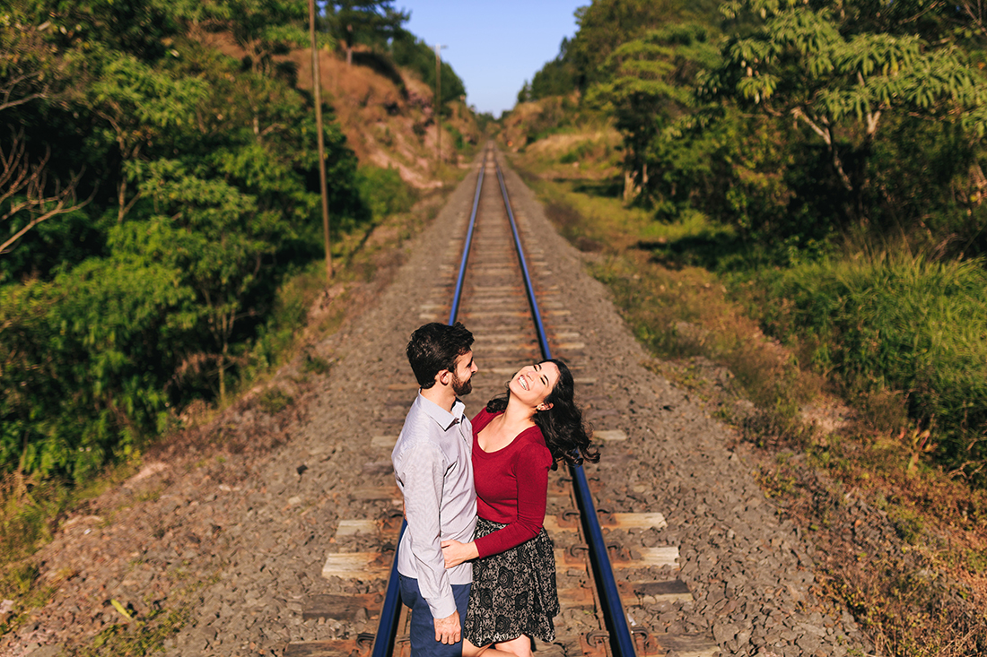 casal dando muita risada na linha do trem