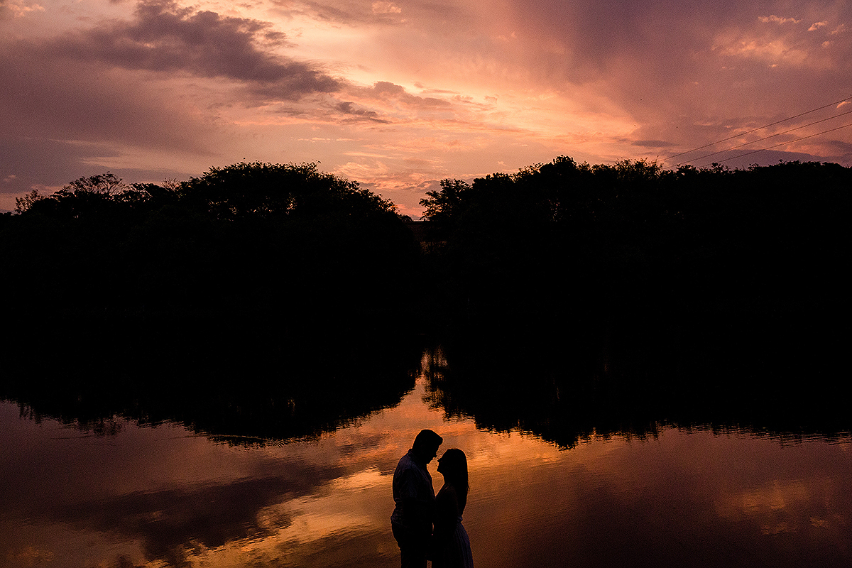 silhueta com por do sol casal se olhando de mãos dadas