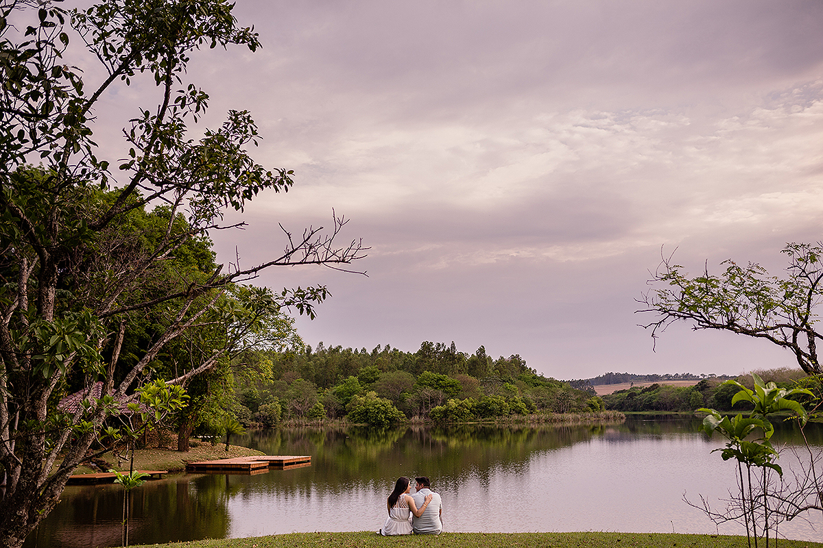 casal sentados no chão com linda paisagem de fundo