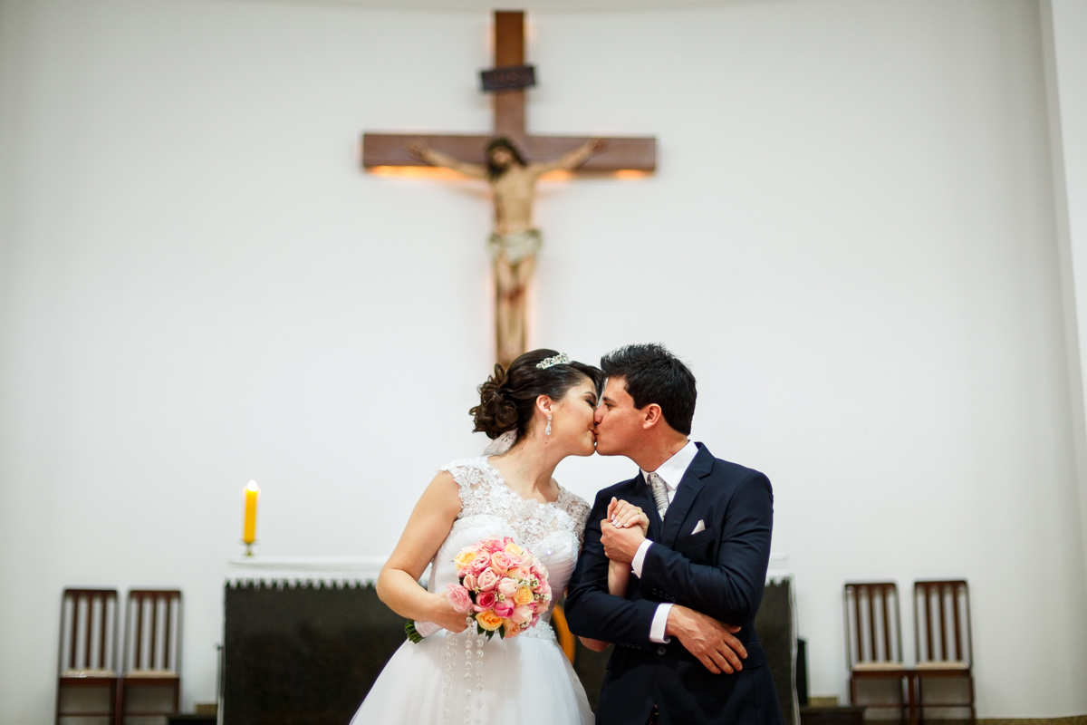 noivos se beijando em frente ao altar