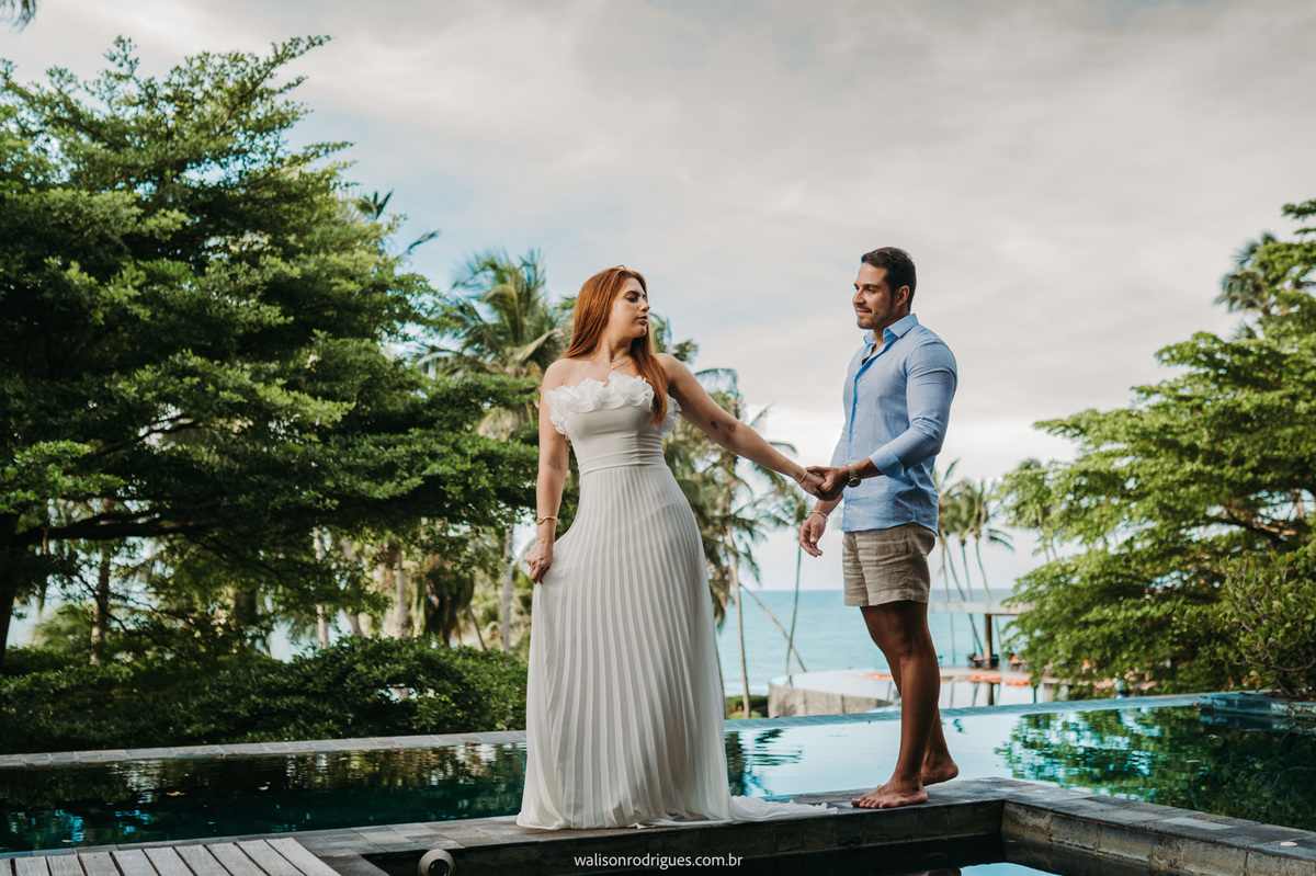 Casal caminhante pela praia no Carmel Taíba Exclusive Resort ao pôr do sol.