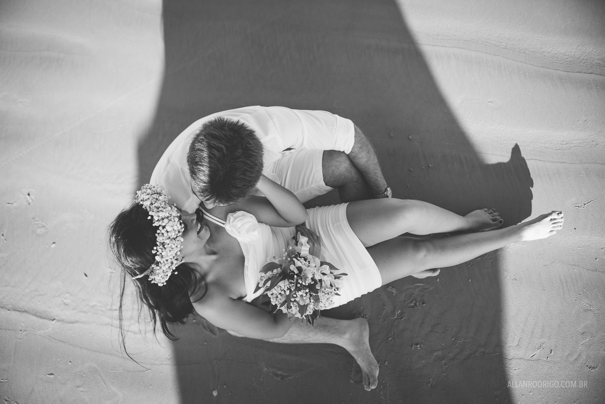 casal sentados na areia da praia