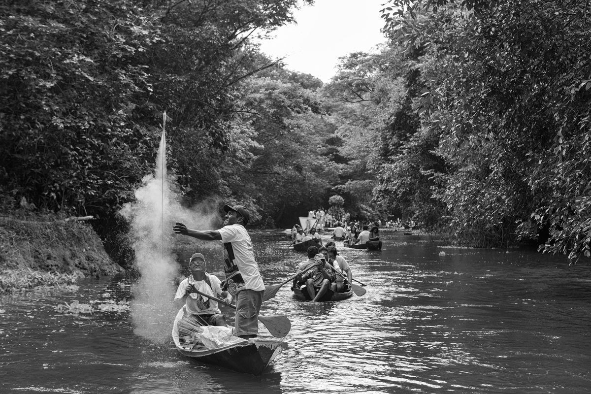 Fiéis soltam fogos em procissão fluvial em Caraparú interior do Pará na fotografia de Romero Cruz