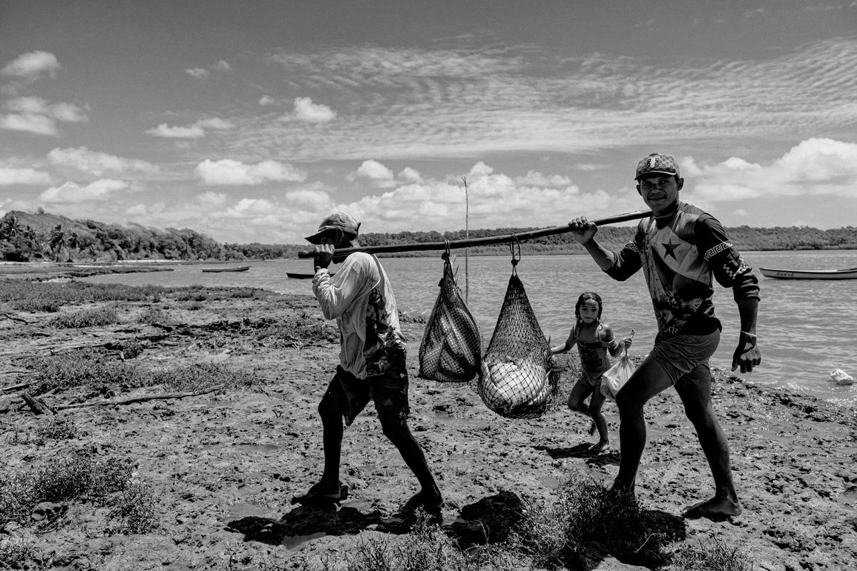 Família de pescadores na Ilha do Marajó levando para casa o resultado da pescaria do dia. Fotografado pelo fotógrafo Romero Cruz.