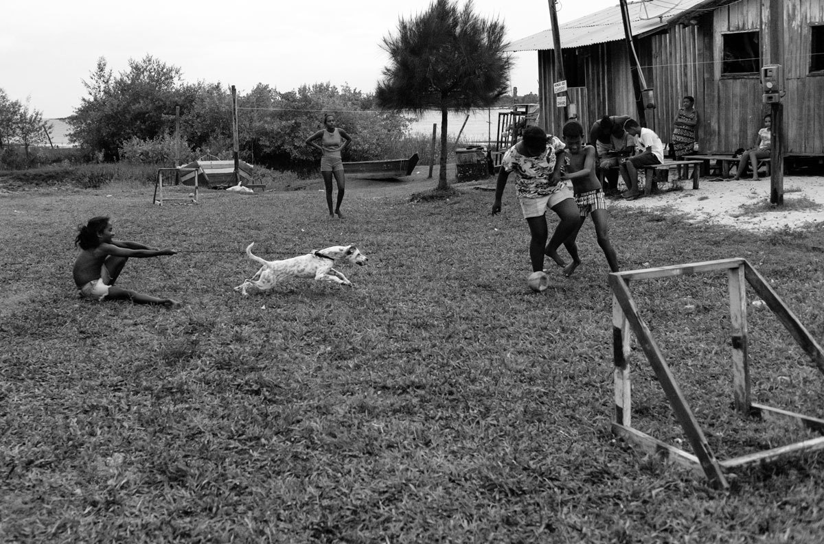 Crianças brincam de futebol com o seu cãozinho na Ilha do Marajó, momento capturado pelo fotógrafo Romero Cruz