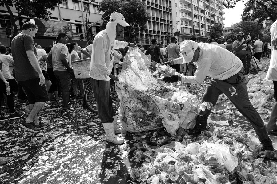 Catadores de recicláveis recolhem lixo reciclável após a passagem da procissão de Nossa Senhora de Nazaré no Círio de Belém do Pará. Momento registrado pelo fotógrafo Romero Cruz