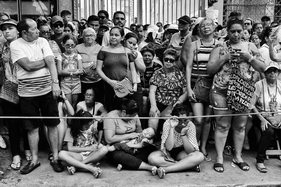 Fiéis entre crianças, jovens, adultos e idosos aguardam a passagem da imagem peregrina de Nossa Senhora de Nazaré na fotografia do fotógrafo profissional Romero Cruz
