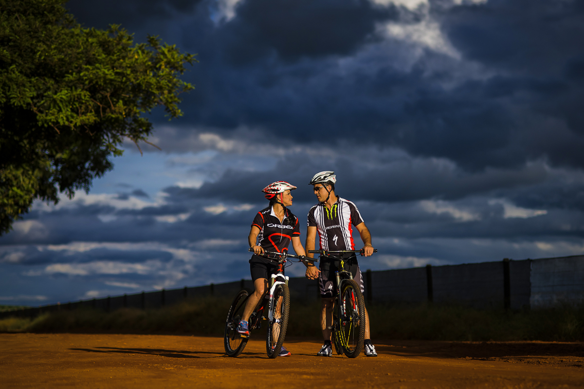 Linda foto com céu nublado e um casal apaixonado em suas bikes