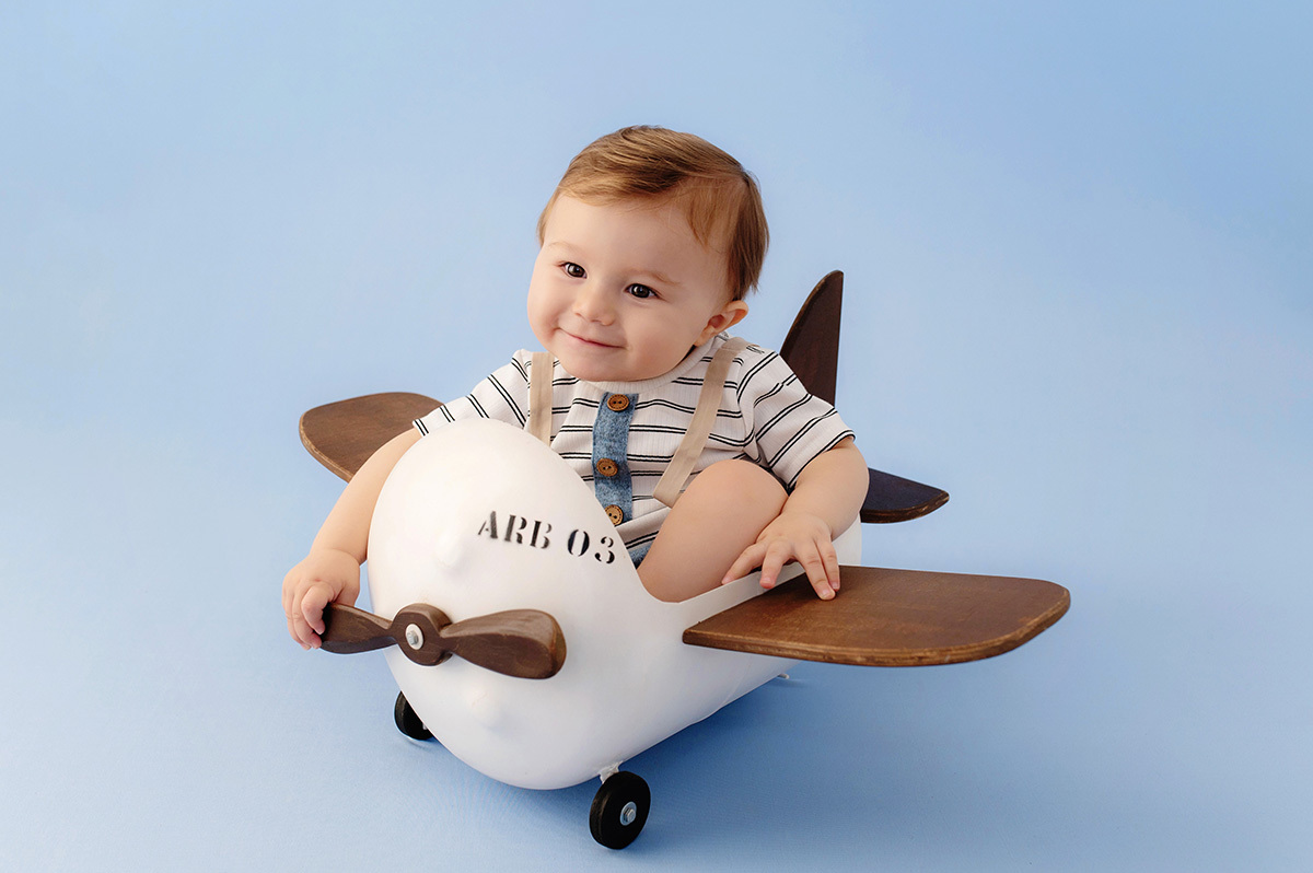 1-aninho-ensaio-foto-infantil-de-menino-no-estudio-romper-azul-avião-branco