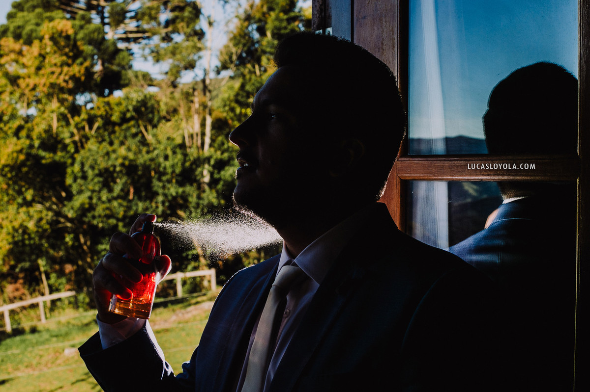 noivo passando perfume no dia do casamento
